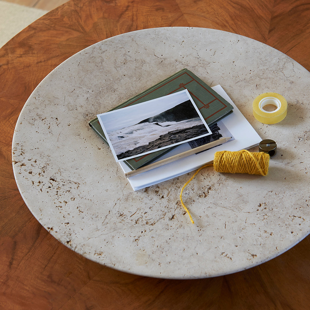 Round speckled beige plate with green and white patterned cards, yellow thread, and tape on a wooden surface.