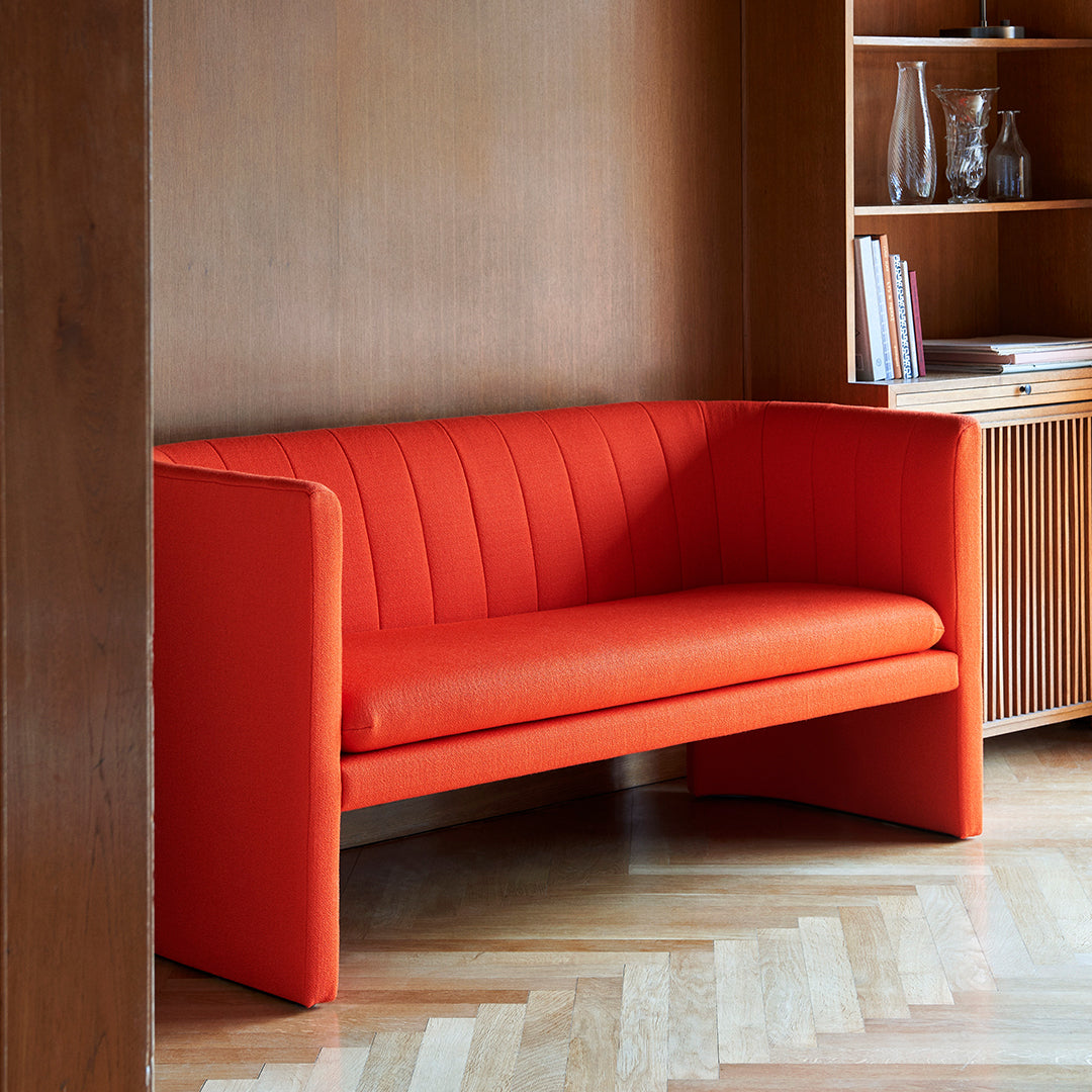 Vibrant orange sofa with vertical striped pattern, ideal for modern decor.
