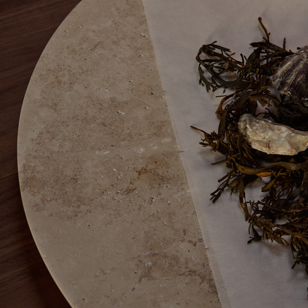 "Natural beige stone surface with earthy green seaweed accents and subtle texture contrasts."