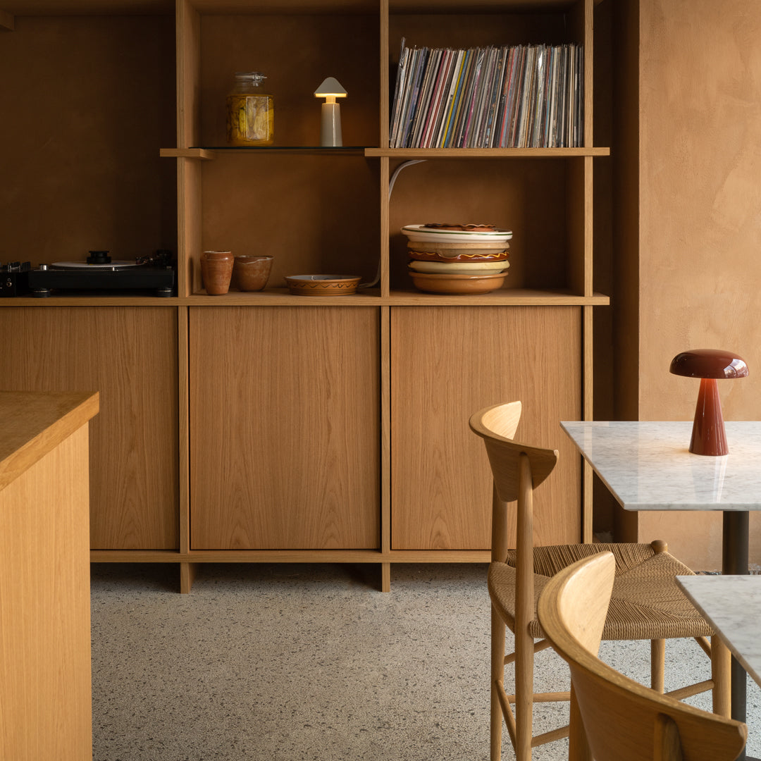"Warm wood tones, earthy beige walls, and soft white marble create a cozy, minimalist aesthetic in this stylish interior."