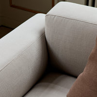 Light gray textured upholstery with a brown accent pillow, showcasing a modern and sleek furniture design.