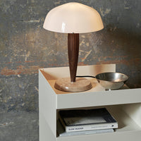 Elegant cream lamp with a smooth dome shade, contrasted by a dark wood base and subtle marble accents.