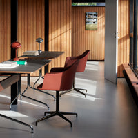 "Modern workspace featuring rich brown chairs, sleek metal accents, and warm wood paneling in a minimalist design."