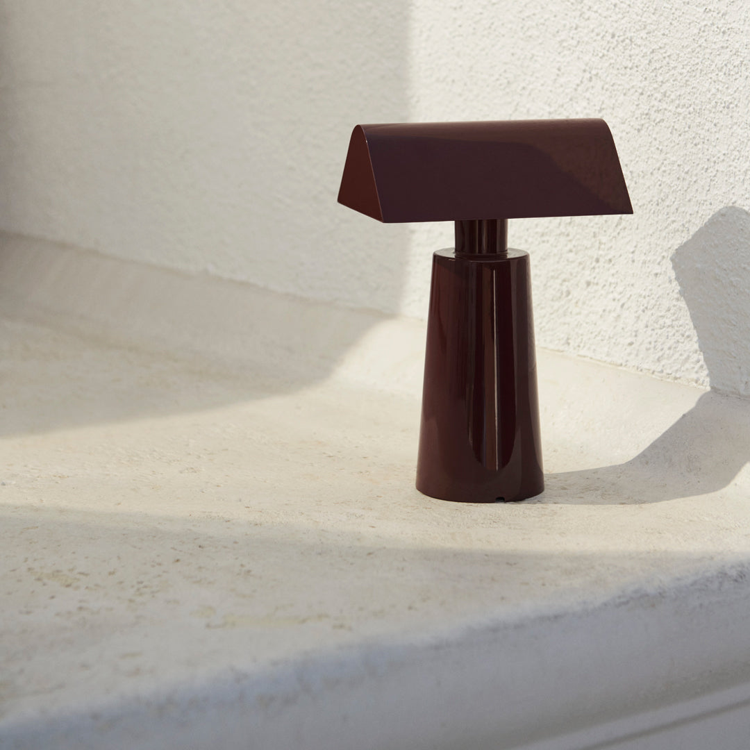 Brown geometric table lamp with a sleek, modern design, showcasing a minimalist aesthetic against a light background.