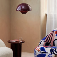 "Stylish living room featuring a burgundy pendant light and a patterned chair in vibrant blue, red, and white hues."