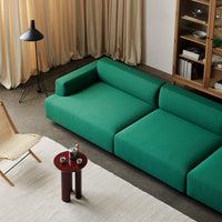 Modern green modular sofa with a smooth, solid pattern, paired with warm-tone decor and earthy accents.