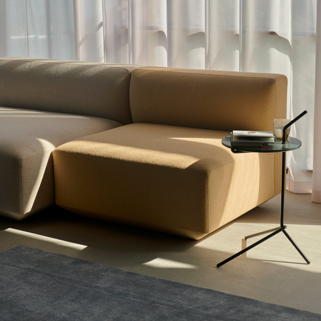 Beige and taupe sectional sofa with a minimalist design, complemented by elegant light conditions.