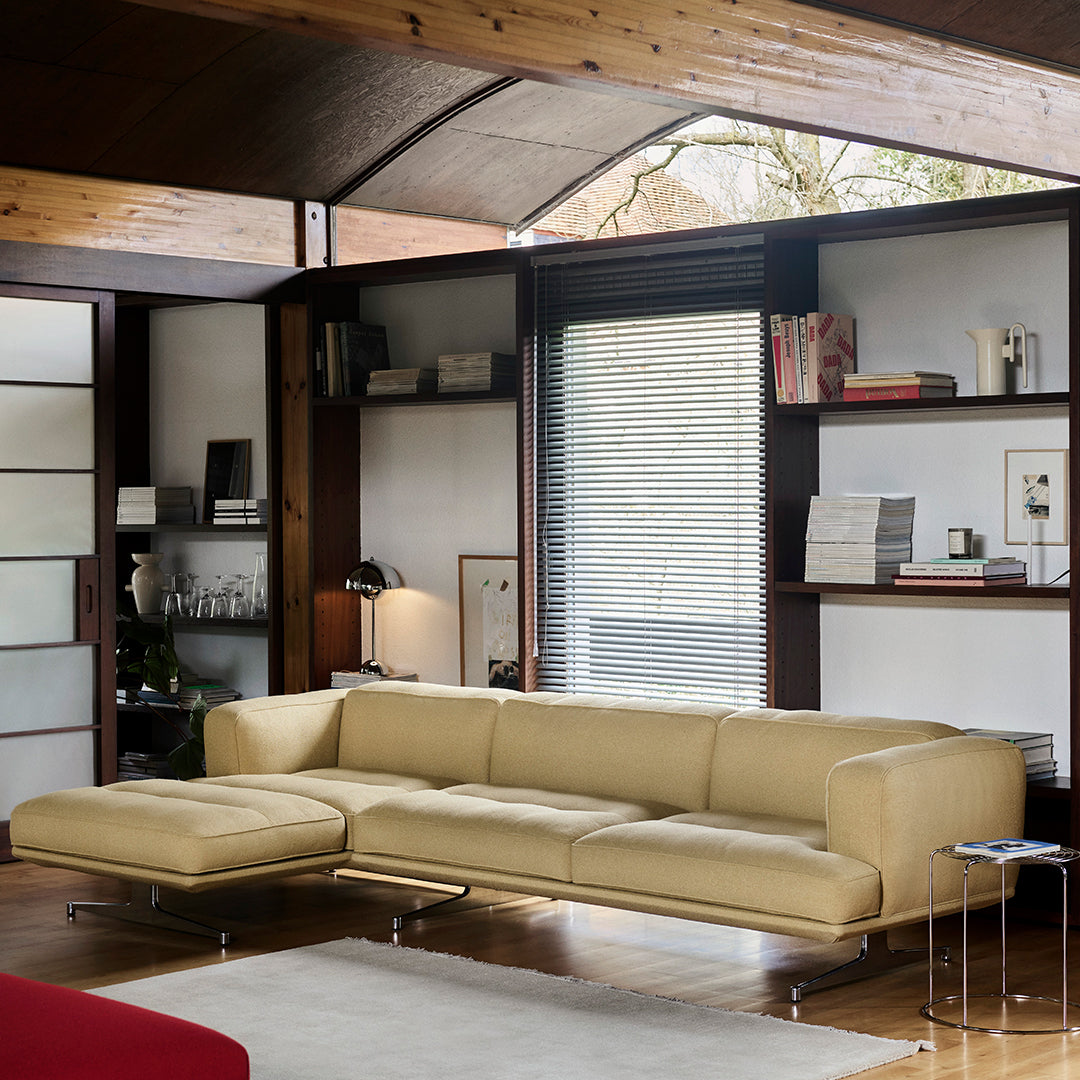 Stylish beige leather couch against a modern interior with warm wood accents and minimalist decor.