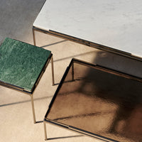 Green marble and reflective bronze tabletops with sleek gold-finished frames. Elegant, modern design for chic interiors.