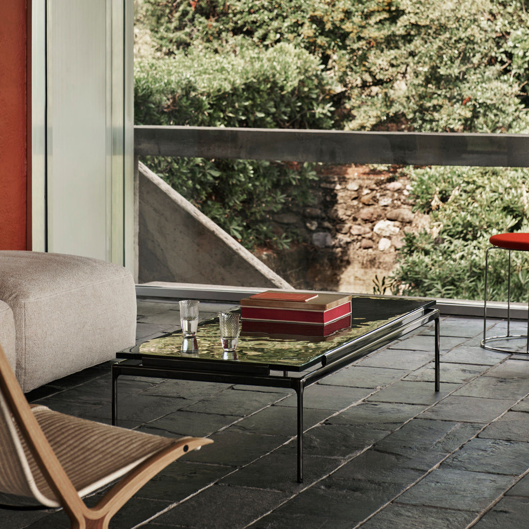 Modern black coffee table with green patterned top, complemented by neutral tones in the surrounding decor.