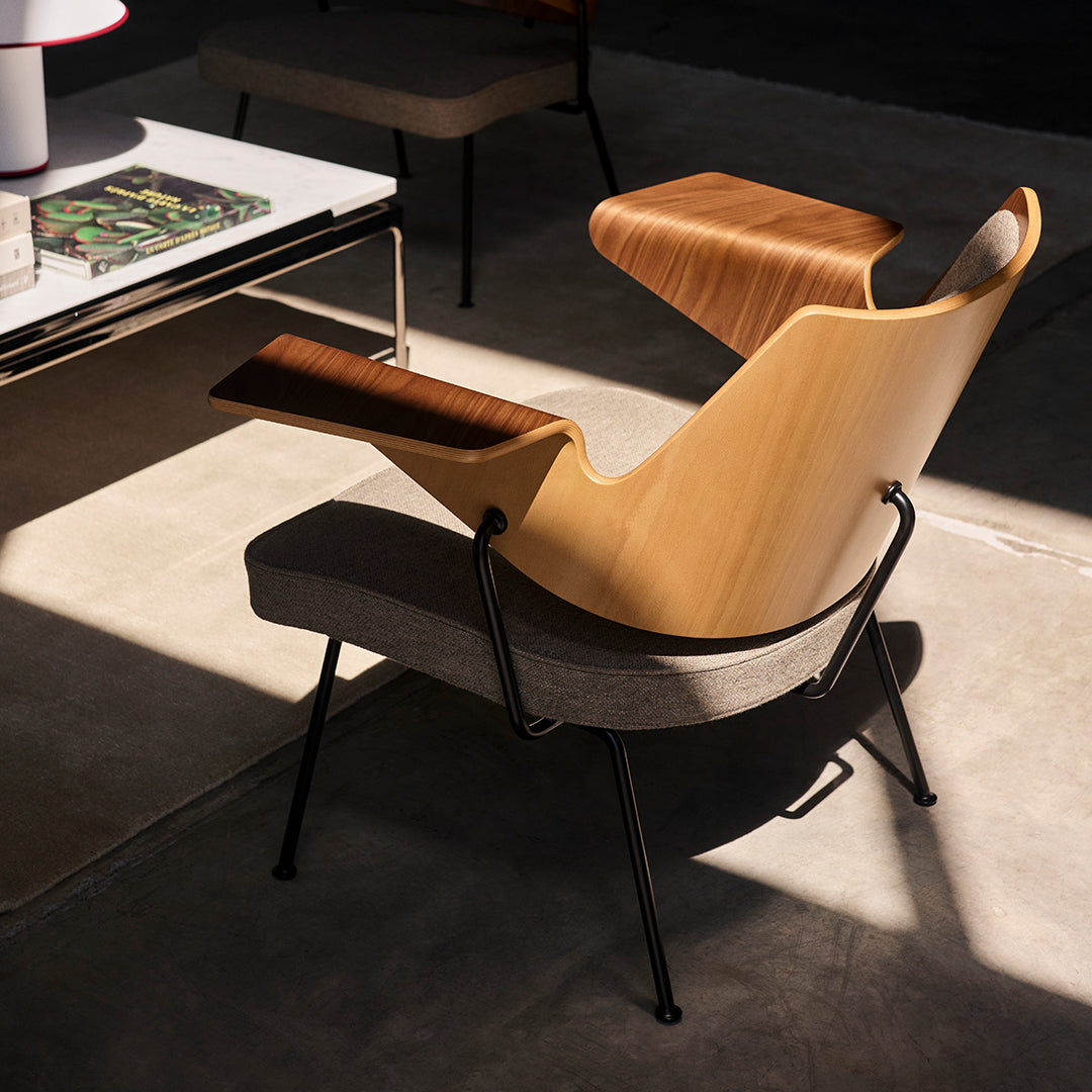 "Modern chair with light wood and gray textile, featuring sleek curves and a minimalist design."