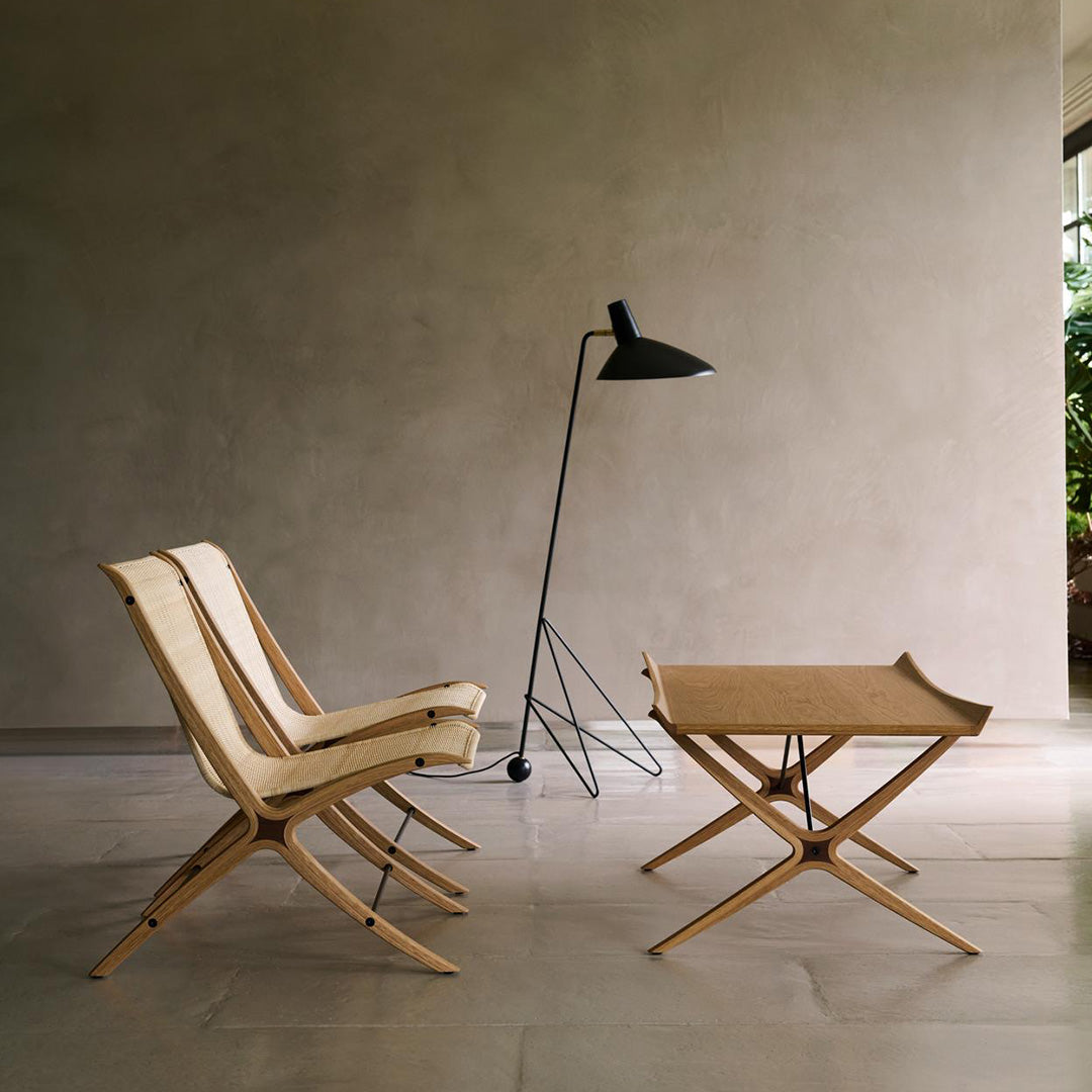 Natural wood chairs and table with a minimalist design; neutral tones and soft textures create a calming atmosphere.