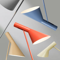 Colorful modern lamps featuring red, blue, tan, and cream tones with sleek, angular designs and matte finishes.