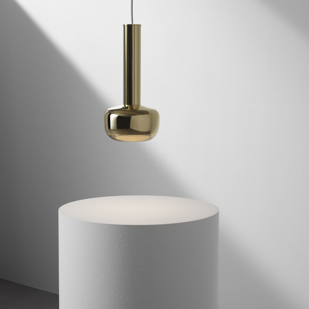 Gold pendant light against a minimalist white backdrop, showcasing sleek, modern design.