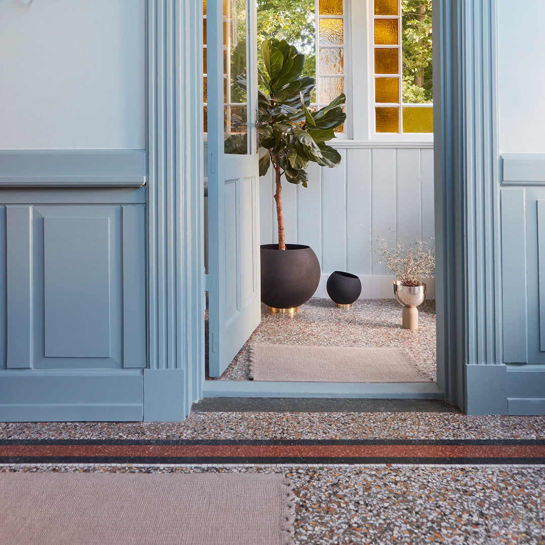 Light blue walls with pastel pink and neutral tones, featuring textured patterns in a stylish entryway.