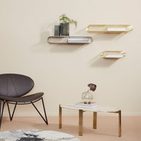"Modern shelves in gold and silver, with a neutral wall and soft pink flooring, complemented by a round patterned rug."