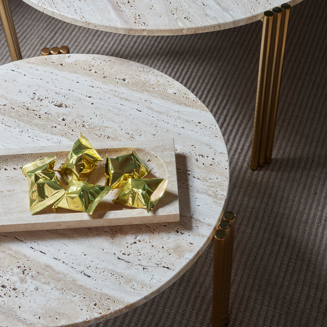 White stone tabletop with natural patterns, gold accents, and a neutral striped surface underneath.