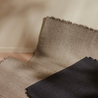 Textured beige and navy striped fabric swatches, showcasing subtle ribbed patterns in a neutral color palette.