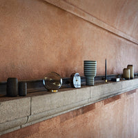 "Elegant collection of black, clear, and striped decorative vases and objects on a textured beige shelf."