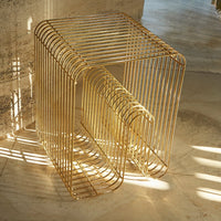 Gold geometric side table with sleek lines and a minimalistic design, creating a modern aesthetic.