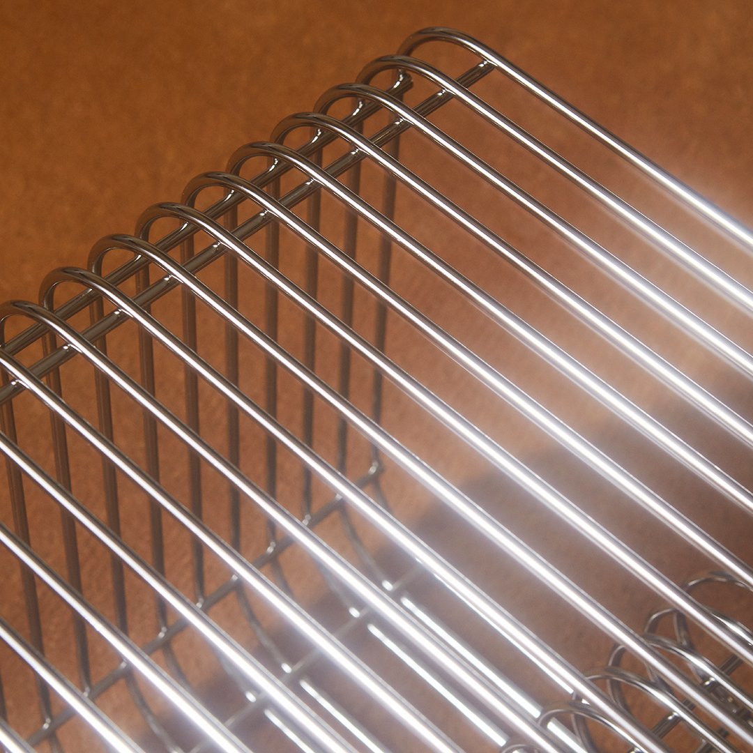 Silver metal wire rack with a sleek, shiny finish, set against a warm brown background.