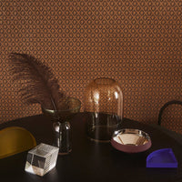 Brown diamond-patterned wallpaper with textured glass and colorful decor items in yellow, purple, and silver accents.