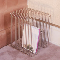 Metal wire magazine rack with a sleek silver finish and minimalist design, showcasing a modern aesthetic.