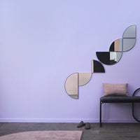 Geometric mirror design featuring black, silver, and gold colors against a soft lavender wall. Stylish and modern decor.