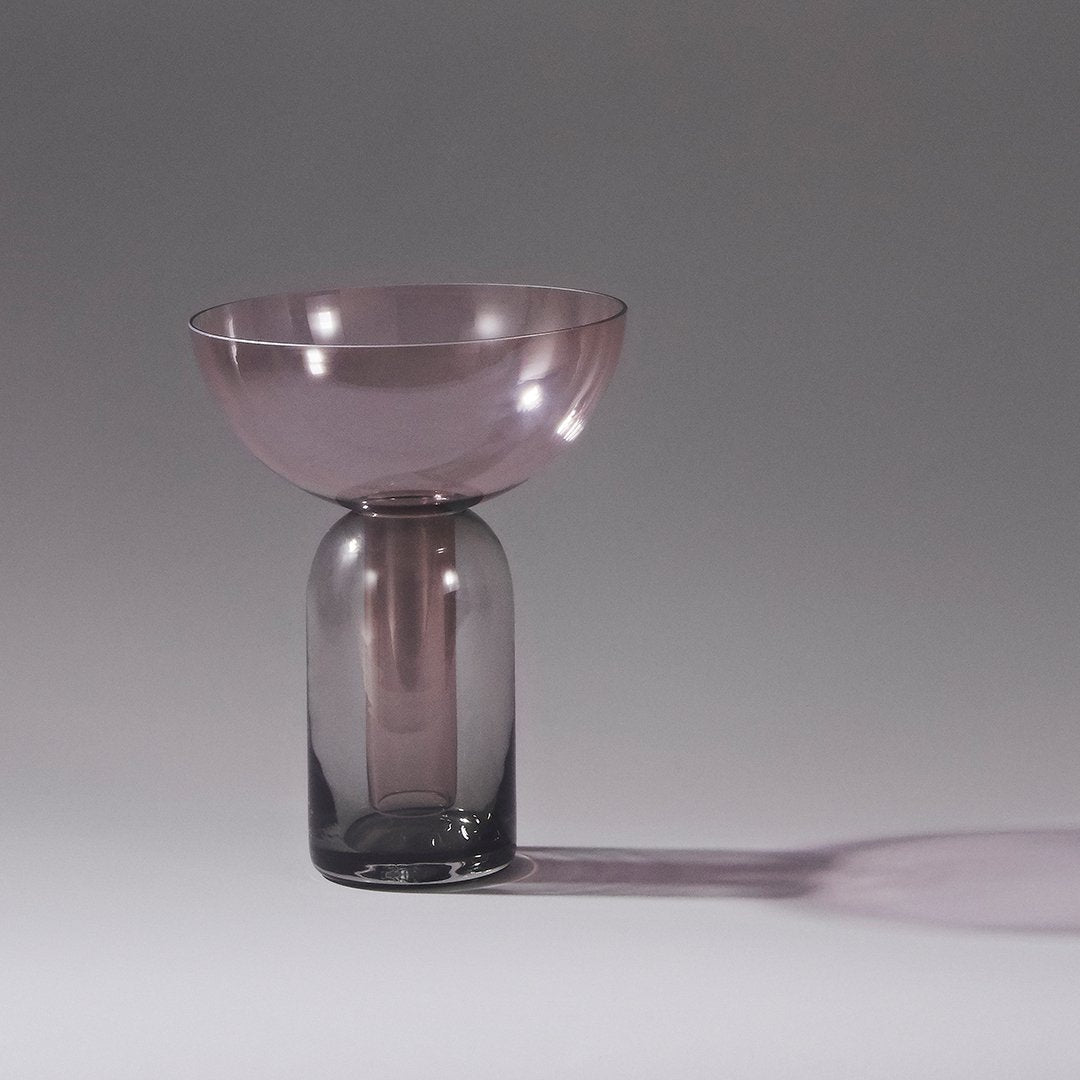 Elegant glass vase featuring a gradient of soft pink and smoky gray hues, showcasing modern, sleek design.