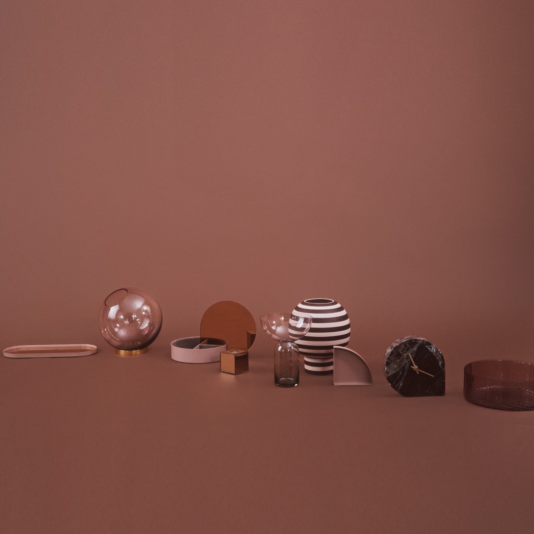 Assorted decorative objects in warm browns and whites, featuring stripes, geometric shapes, and glossy finishes.