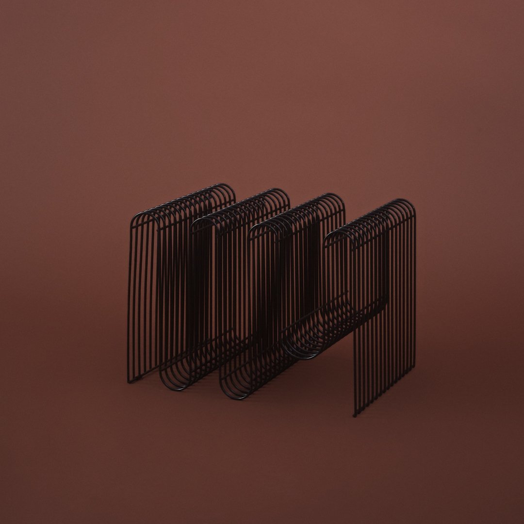 Black metal wire design with geometric lines against a solid brown background, creating a modern aesthetic.
