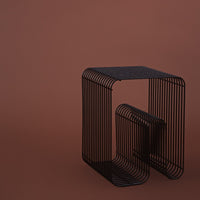 Black wireframe side table against a solid brown background, featuring sleek lines and minimalist design.