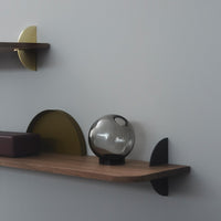 Modern shelf with gold, black, and green accents; features circular and semi-circular shapes for a balanced aesthetic.