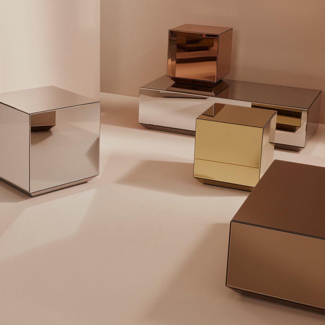 Reflective metal accent tables in silver, gold, and copper finishes with sleek geometric designs.