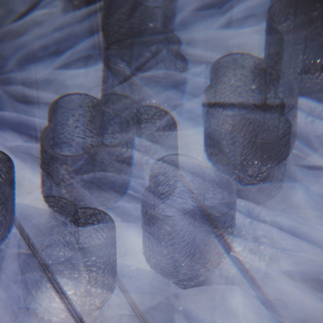 Abstract image featuring dark blue and gray cylindrical shapes with a soft, blurred pattern in the background.