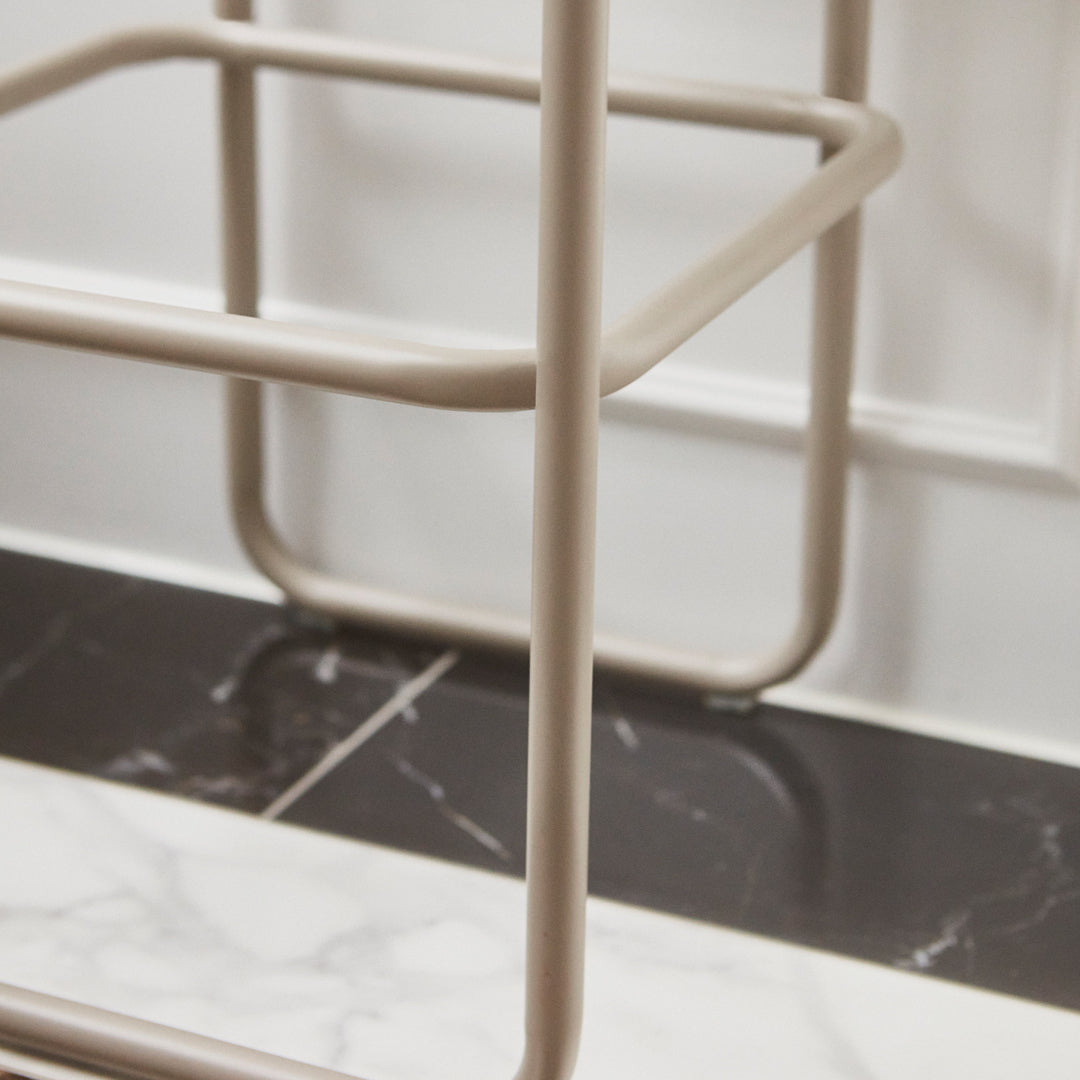 Beige metal frame against a matte black and white marbled surface, showcasing a modern minimalist design.