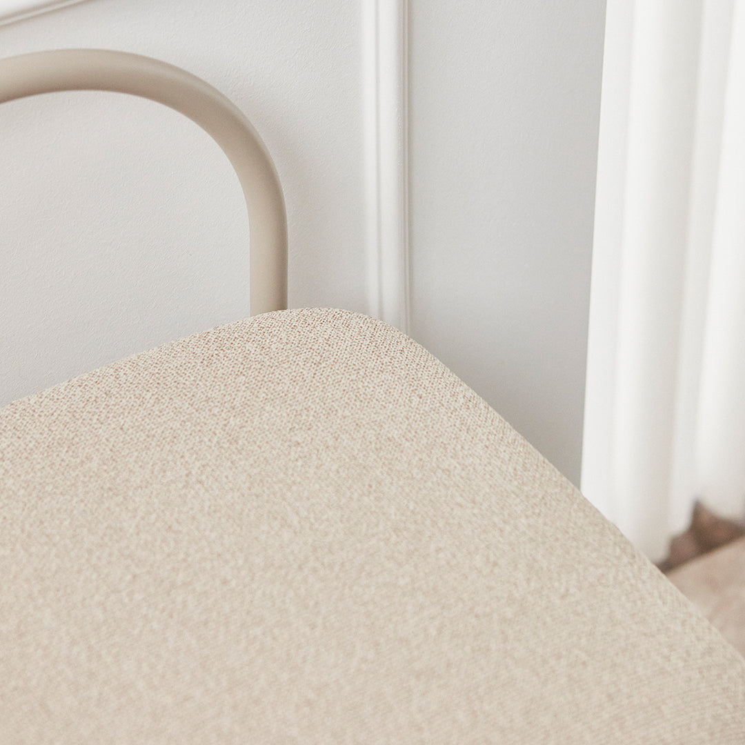 Beige textured surface with soft neutral tones, complemented by a light-colored frame against a subtle background.