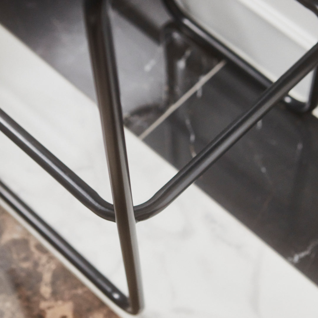 Black metal frame on a marble-patterned surface, showcasing sleek lines and modern design elements.