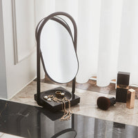 Stylish black and gold jewelry organizer with an oval mirror and sleek curved frame, perfect for modern decor.