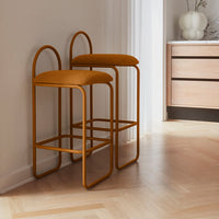 Modern mustard yellow bar stools with sleek metal frames, featuring a minimalist design and soft upholstery.