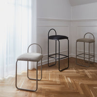 "Set of three modern bar stools in beige, black, and grey with sleek metal frames and minimalist design."