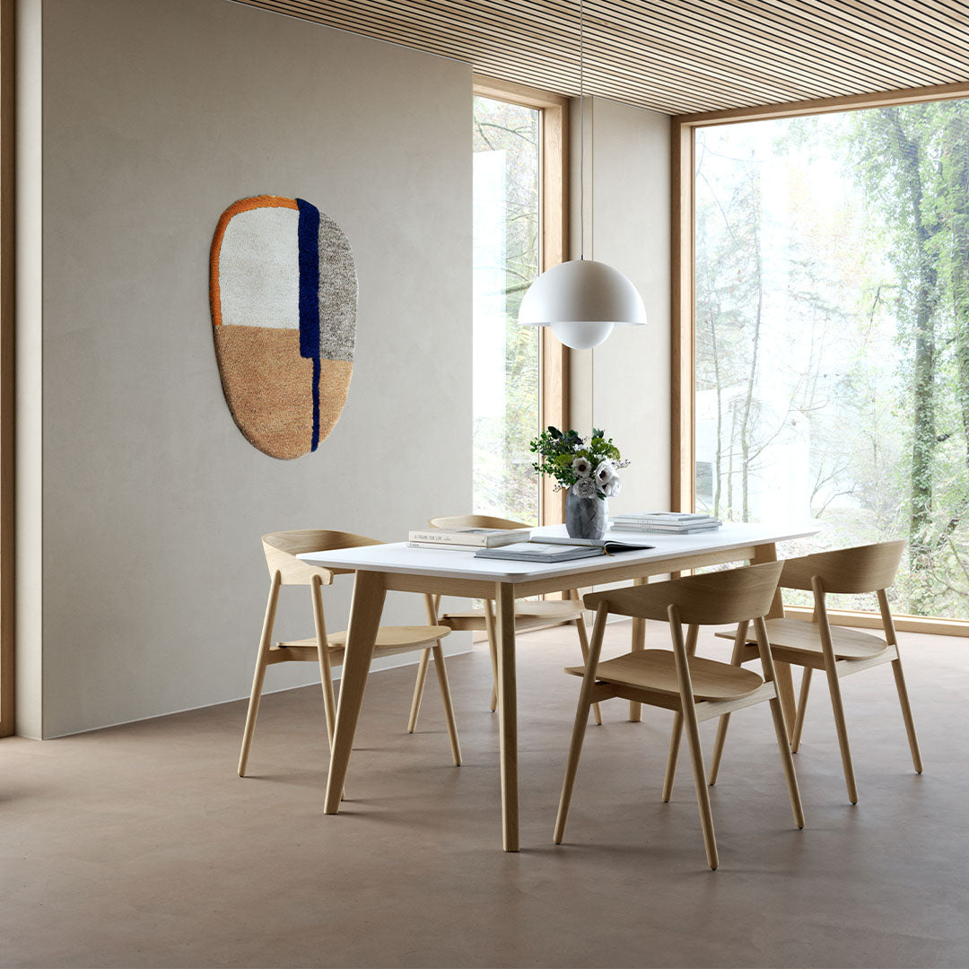 "Modern wall art with earthy tones, vibrant orange, navy blue, and textured patterns in a bright, airy setting."