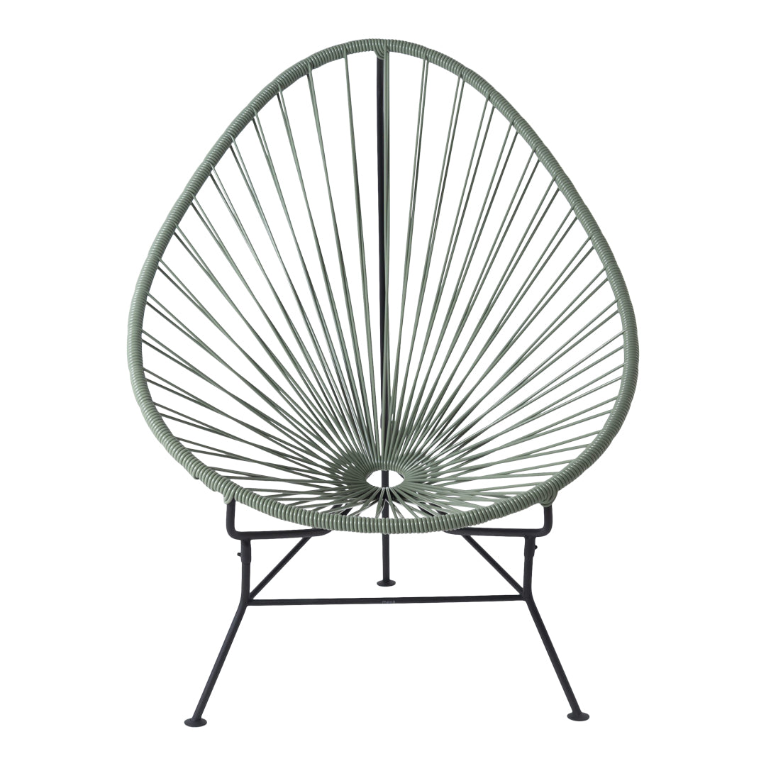 Green Acapulco chair with a unique open lattice design and black metal frame, perfect for modern outdoor decor.