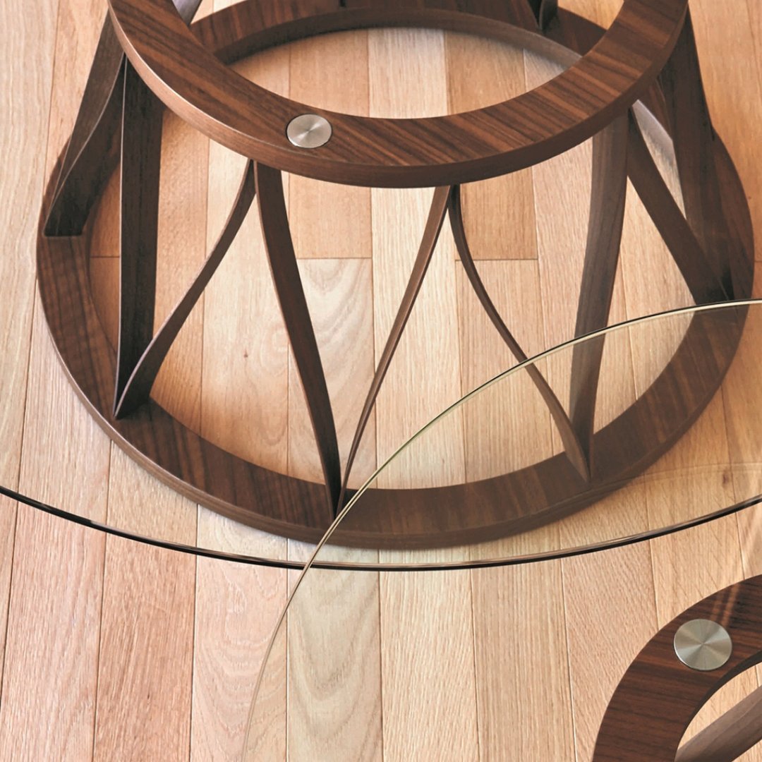 Stylish walnut wood base with circular glass top and modern geometric pattern on a light wood floor.