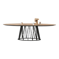 Oval wooden dining table with a light brown top and a sleek black geometric base, showcasing modern design.