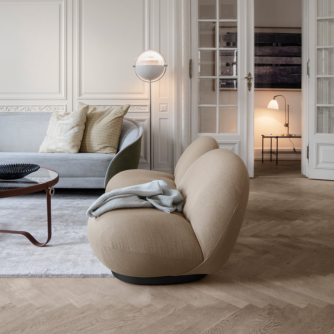Beige curved sofa with a soft texture, paired with neutral tones in a modern, minimalist room setting.