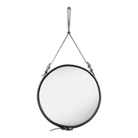 Round wall mirror with a sleek black leather strap and brass accents, featuring a minimalist design.