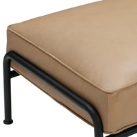 Tan leather cushion with smooth texture and black metal frame, showcasing modern minimalist design.