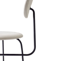 Light beige chair with a minimalist design, featuring a sleek black metal frame.