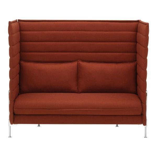 Rust orange two-seater sofa with vertical stitched pattern and plush cushions, set on sleek metal legs.